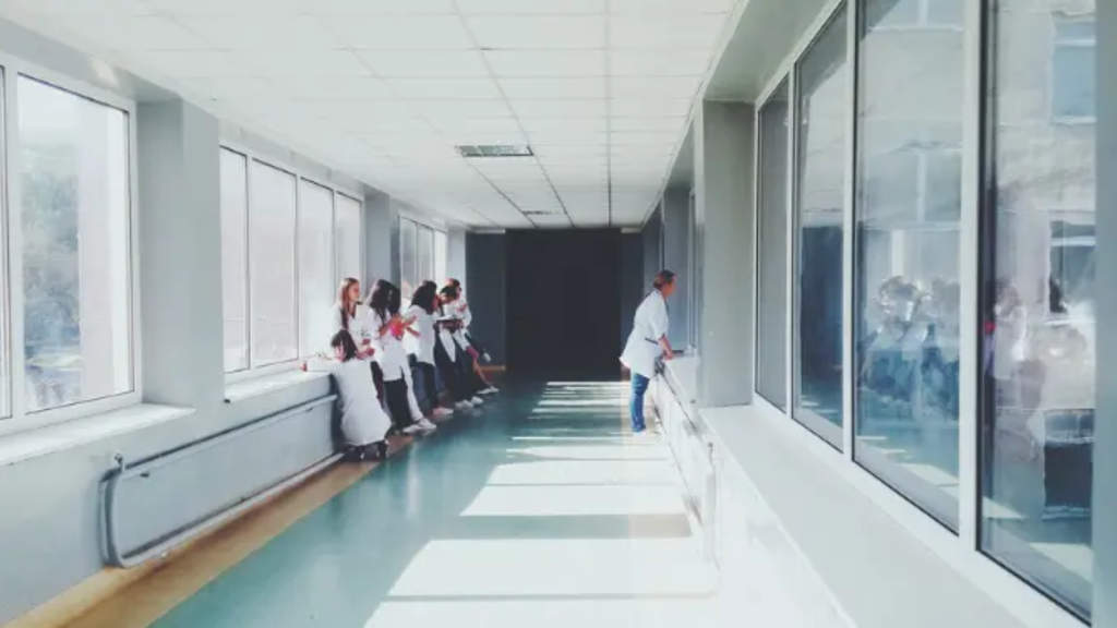 Hospital hallway with students observing a procedure